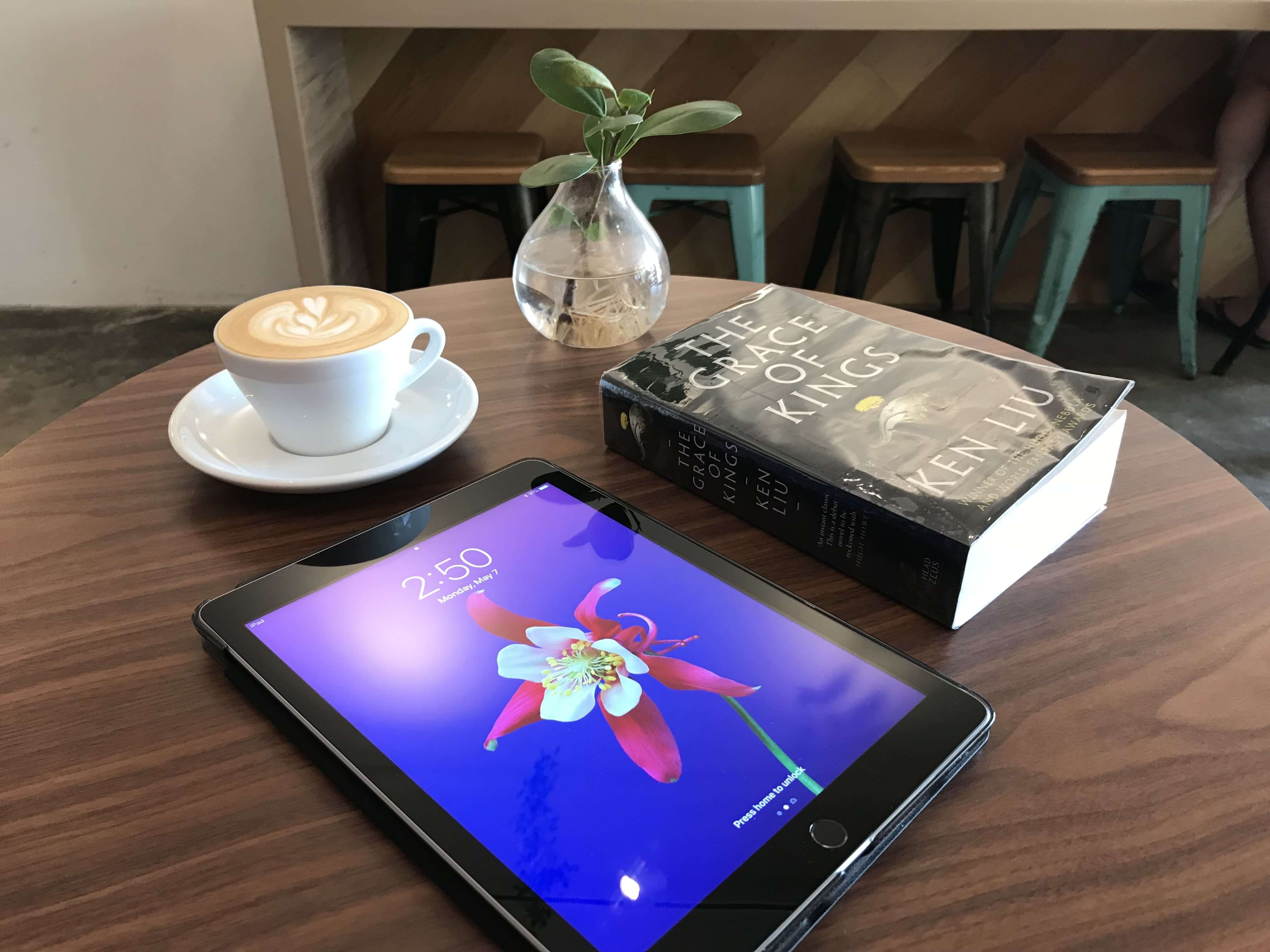 A novel and iPad on a cafe table
