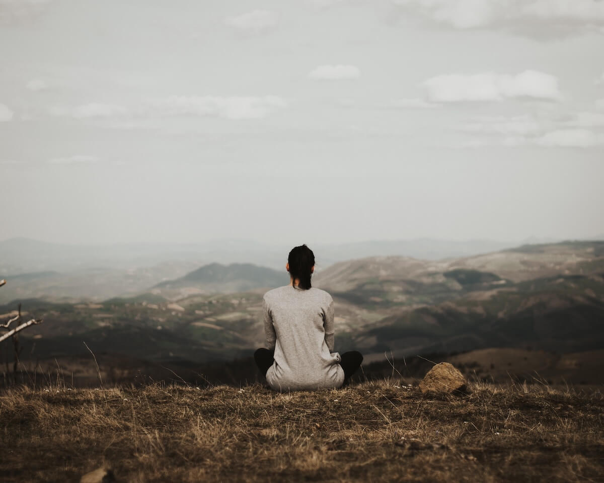 Woman meditating on a hill