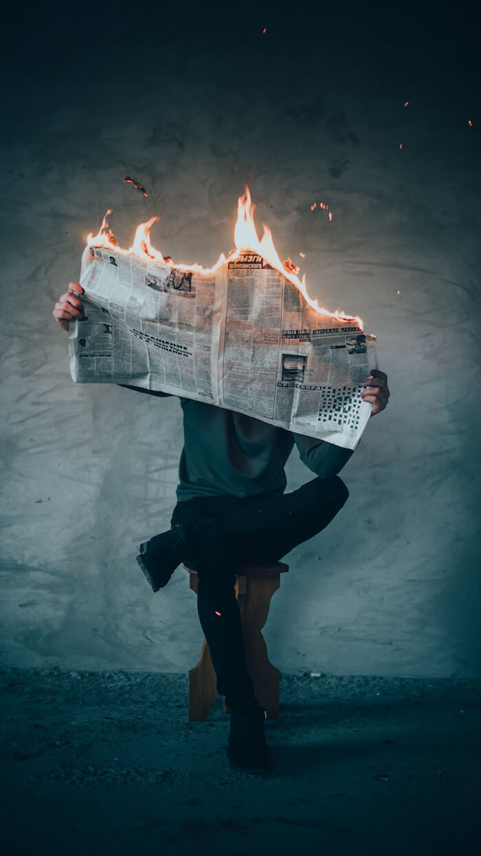 Man reading a newspaper on fire